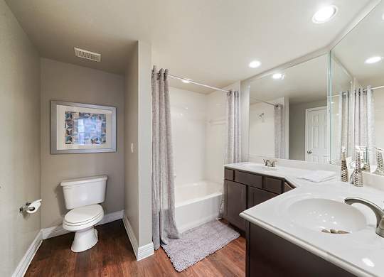 A bathroom with a white toilet, a white sink, and a white bathtub.