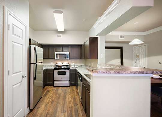 A kitchen with a white door and a white counter.