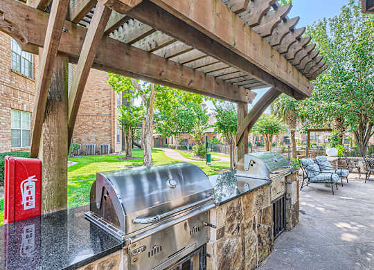 A patio with a grill and seating area.