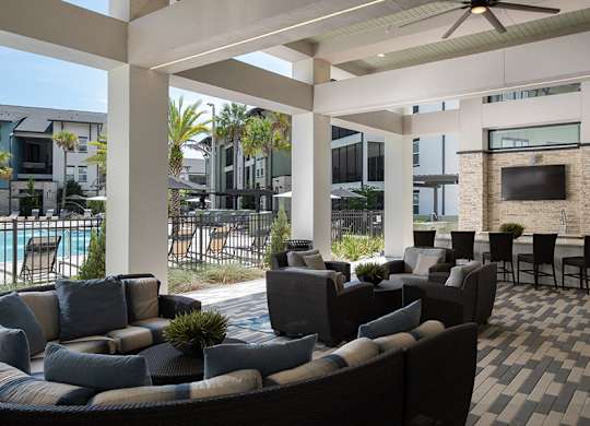 A patio with a black and white checkered floor and a stone wall.