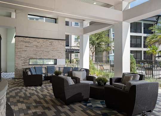 A patio with a black railing and a stone fireplace.