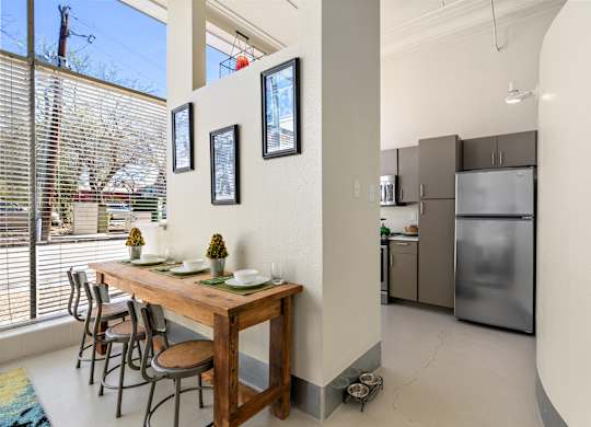 A kitchen with a table and chairs in front of a window.