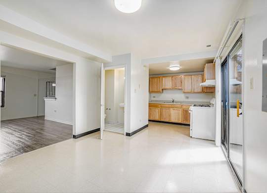 A kitchen area with a refrigerator, sink, and cabinets.