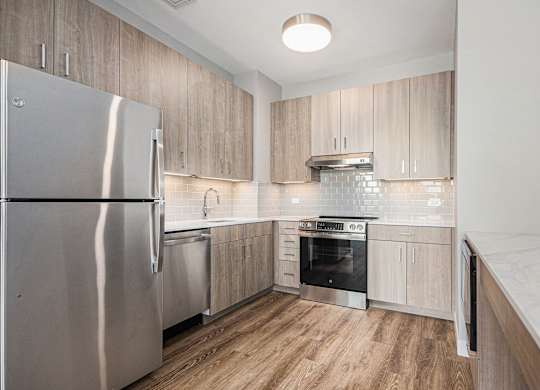 Modern kitchen with a stainless steel refrigerator and wooden cabinets at Thrive Exchange, Illinois , 60617