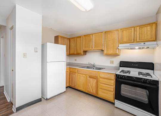A kitchen with wooden cabinets and a white refrigerator.