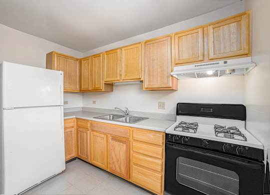 A kitchen with wooden cabinets and a white refrigerator.