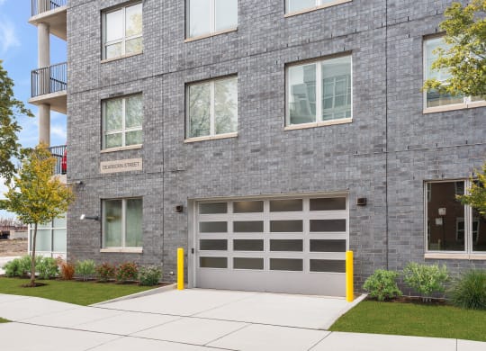 a gray brick building with a garage door on the side of it