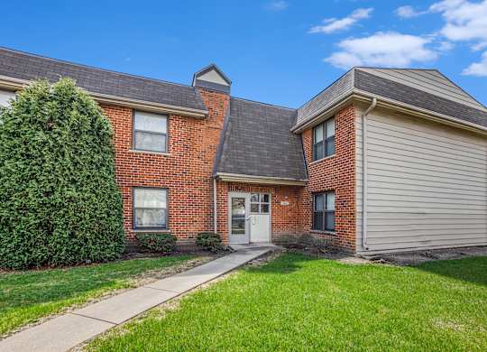 A house with a brick facade and a grey garage door.