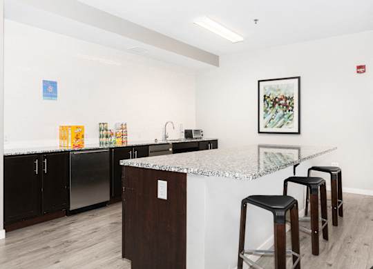 a kitchen with a counter top and three stools