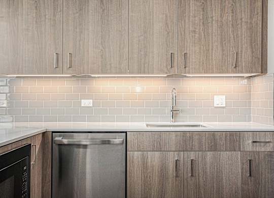 Stainless steel dishwasher and wooden cabinets in kitchen at Thrive Exchange, Chicago, IL