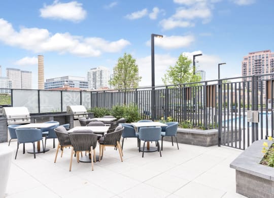 an outdoor patio with tables and chairs and a view of the city  at Cassidy on Canal, Chicago, IL
