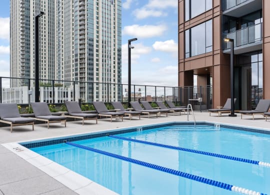 a swimming pool on the rooftop of a building with lounge chairs at Cassidy on Canal, Chicago, IL, 60654