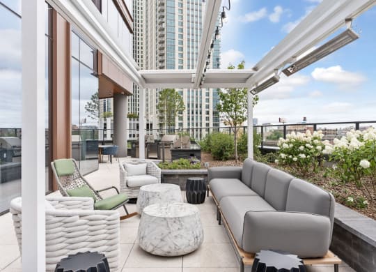 a living area with couches and chairs and a balcony with tall buildings at Cassidy on Canal, Chicago, IL, 60654