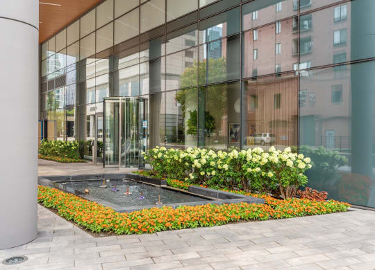 a courtyard with flowers in front of a glass building  at Cassidy on Canal, Illinois, 60606