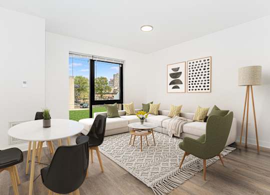A living room with a white couch, a white table, and a green chair.