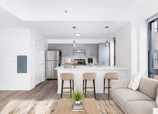 A modern kitchen with a bar stool and a couch.