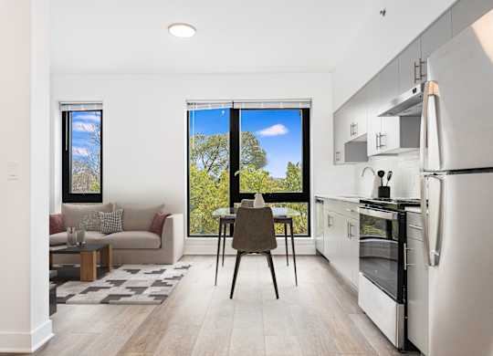 A kitchen with a refrigerator, oven, and sink.