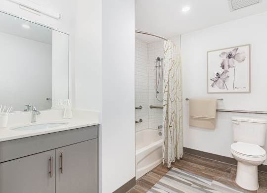 A bathroom with a toilet, sink, and shower.