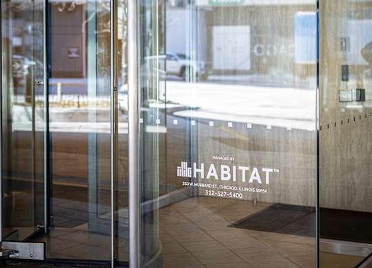 The image shows the entrance to a building with a glass door and a sign that reads