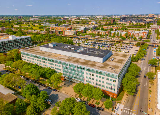 an aerial view of a large building with trees in front of it and a city in the