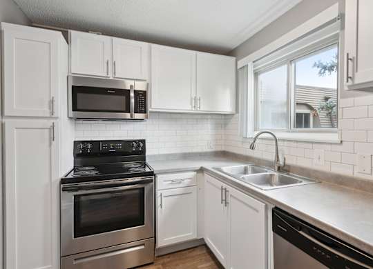 Modern kitchen with white cabinets and stainless appliances at Cedarvale Highlands Apartments, Eagan, 55122