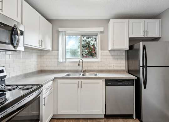 Modern kitchen with white cabinets and stainless appliances1 at Cedarvale Highlands Apartments, Eagan, Minnesota