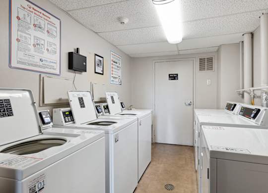 Laundry room with white washers and dryers at Cedarvale Highlands Apartments, Minnesota, 55122