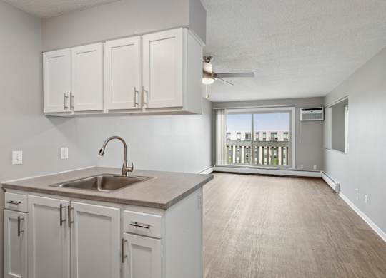 Modern apartment kitchen with peninsula and living space at Cedarvale Highlands Apartments, Eagan, 55122