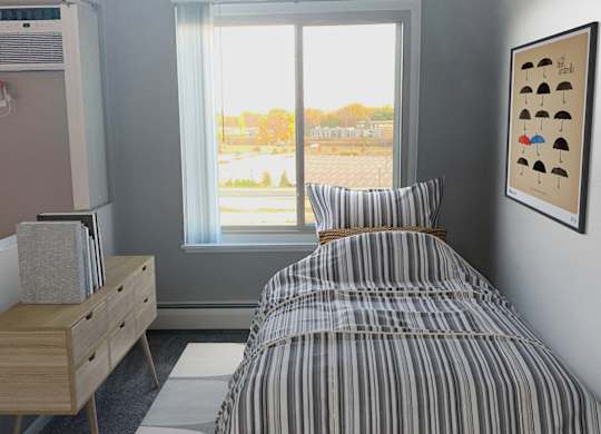 Bright bedroom with striped bedding and window view at Cedarvale Highlands Apartments, Eagan
