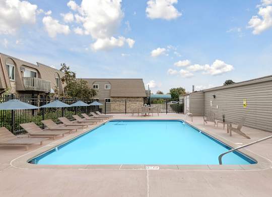 Swimming pool with lounge chairs and umbrellas2 at Cedarvale Highlands Apartments, Eagan, MN