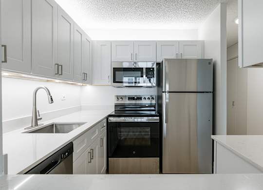A modern kitchen with stainless steel appliances and white cabinetry at Columbus Plaza, Illinois, 60601