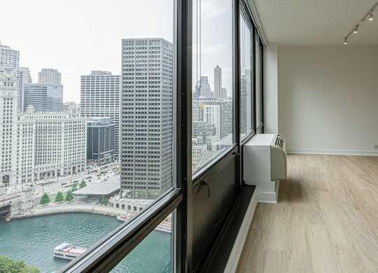 A room with a large window overlooking a river and city buildings at Columbus Plaza, Chicago, Illinois