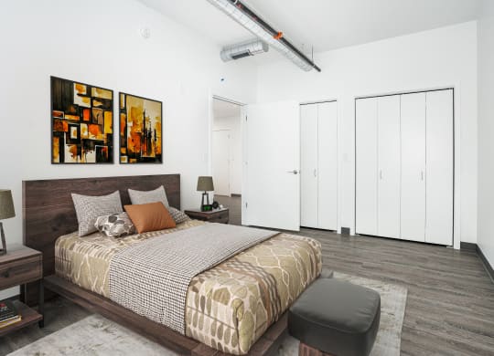 a bedroom with a bed and two paintings on the wall