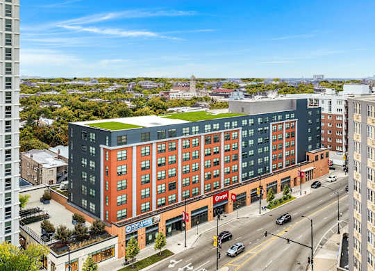 a large building with a green roof on a city street