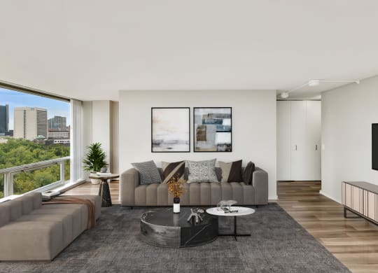 a living room with white walls and a large window with a city view at The Pavilion, Detroit, MI, 48207