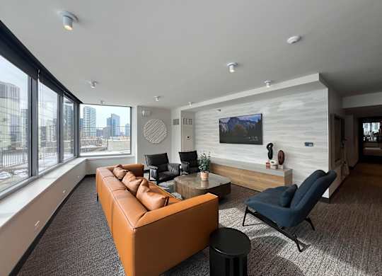A modern living room with a brown leather couch and a blue chair at Kingsbury Plaza, Chicago, Illinois, 60654