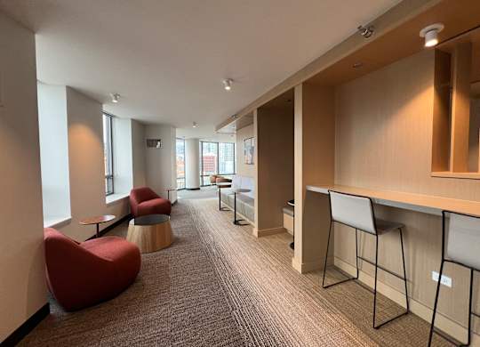 A long hallway with a row of chairs and a desk at Kingsbury Plaza, Chicago