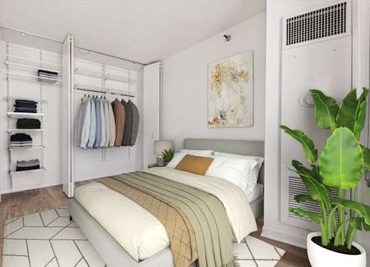 A bedroom with a bed, a wardrobe, and a plant.