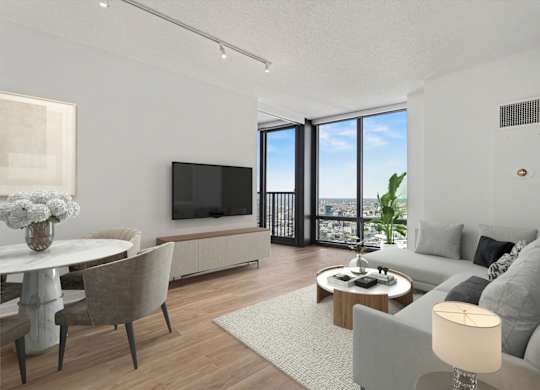 A modern living room with a grey sofa, a white coffee table, and a flat screen TV.