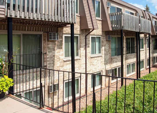 Multi story apartment building with balconies and brick exterior at Cedarvale Highlands Apartments, Minnesota