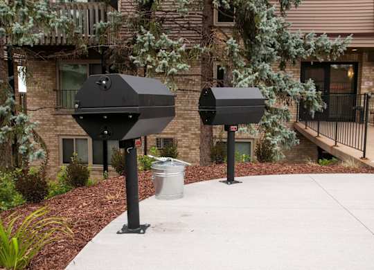 Outdoor barbecue grills with landscaped courtyard at Cedarvale Highlands Apartments, Minnesota, 55122