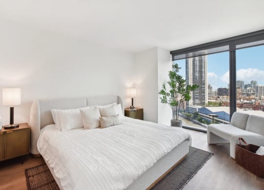 a white bedroom with a large bed and a view of the city at Cassidy on Canal, Chicago, IL, 60654