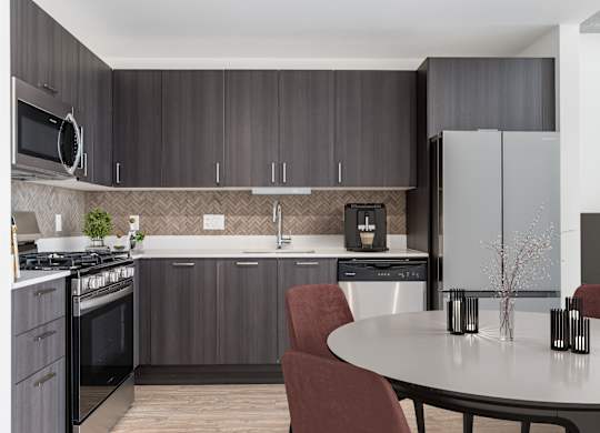 A modern kitchen with a round table and chairs.