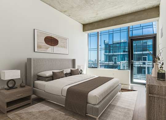 A bedroom with a large bed and a large window.