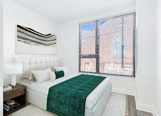 a bedroom with a large window and a bed with a green blanket