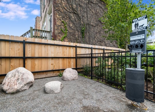 a fence with rocks and a sign in front of a building