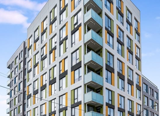 a rendering of a new apartment building on a city street