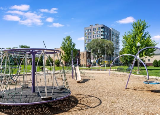 a playground at a park with a building in the background
