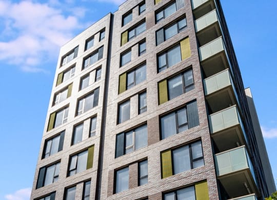a tall building with many windows and a blue sky
