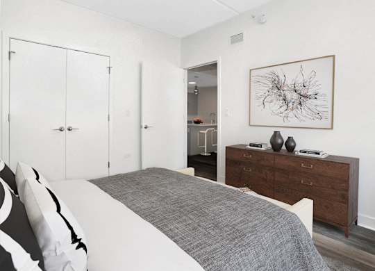 a bedroom with a bed and a dresser and a painting on the wall